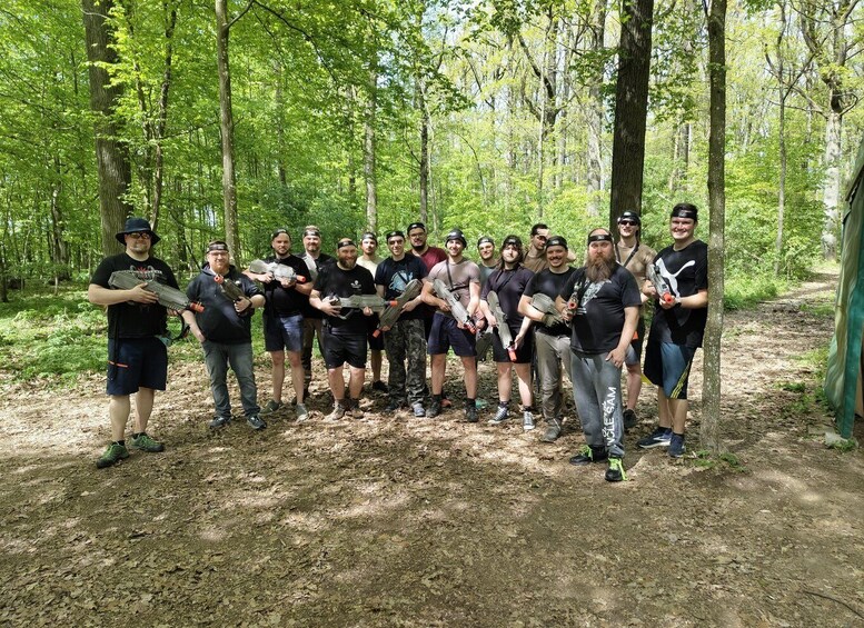 A group of people in a forested area with trees and a dirt path. 4