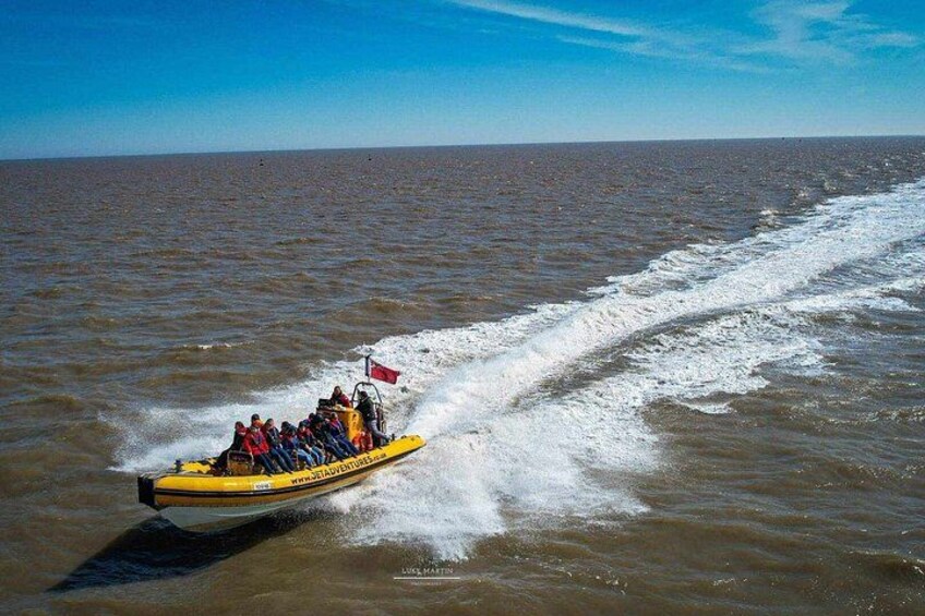 A yellow boat with people on board moving through a body of water. 2