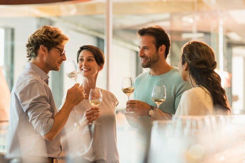 A group of people holding wine glasses in a well-lit indoor setting. 4