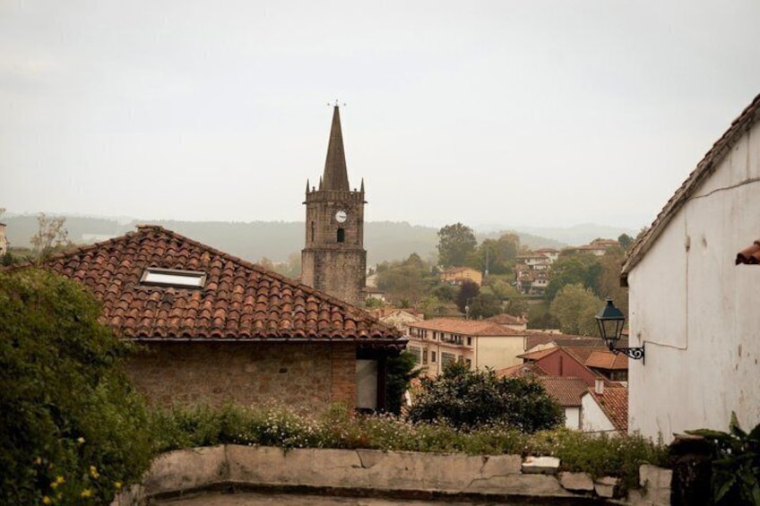 A town with a church tower, a white building with a lamp post, and a red-tiled roof house. 4