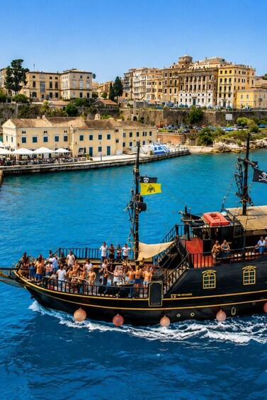 A boat with passengers, a coastal town, and a clear blue sea. 3