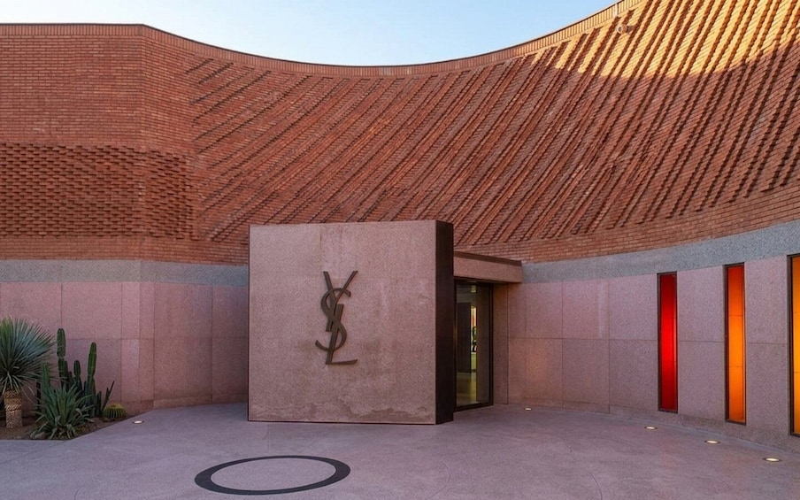 A building with a distinctive curved roof and a central sculpture. 4