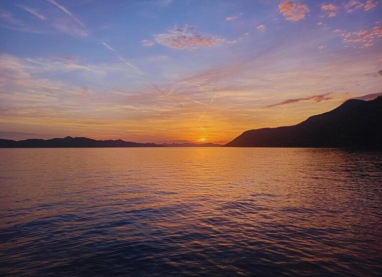 A sunset over a calm lake with mountains in the background. 5