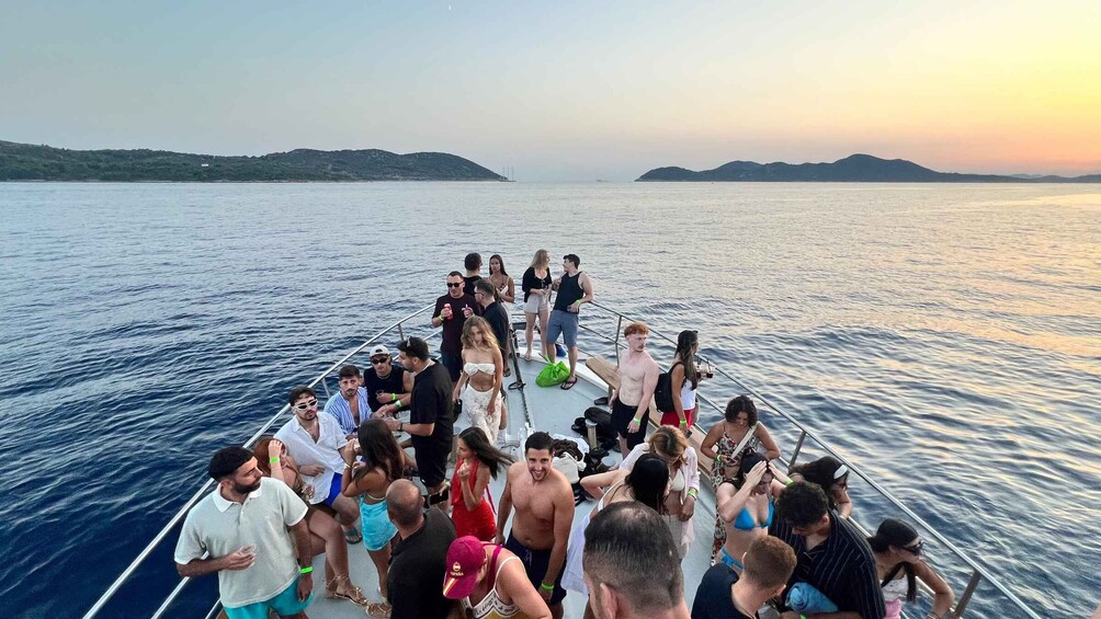 A group of people on a boat with a calm sea and distant land in the background. 4