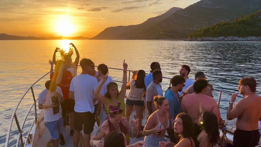 A group of people on a boat at sunset with mountains in the background. 3