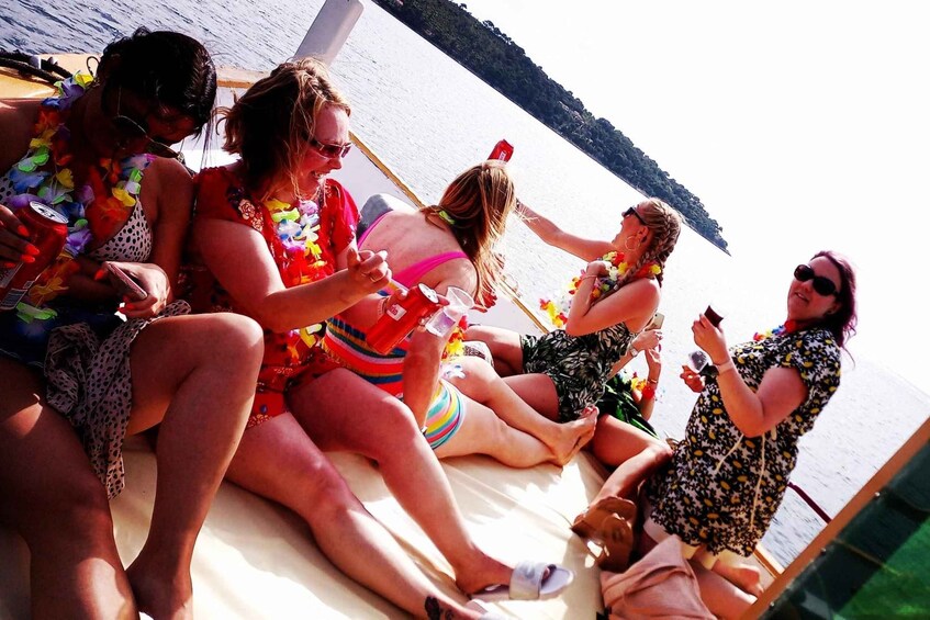 A group of people sitting on a boat with a lake and hills in the background. 5