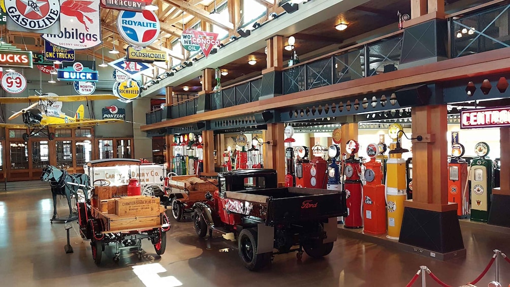 A vintage-themed indoor exhibit with antique vehicles and gas pumps. 3