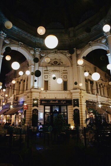 A historic building with ornate architecture, including columns and arches, and a cafe named 'Remolle Cafe' at the ground level. 4