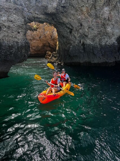 A group kayaking through a narrow waterway between rocky cliffs. 3
