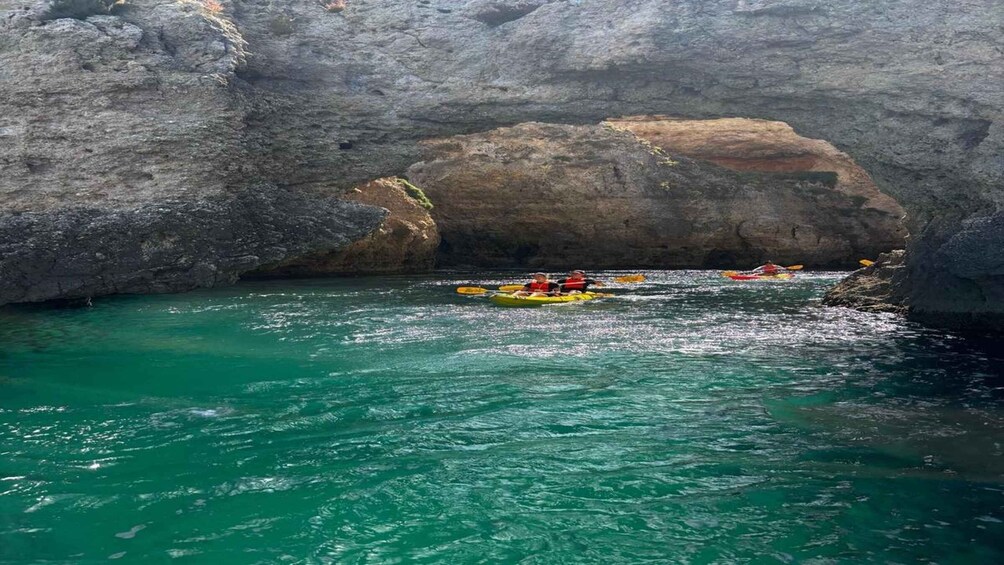 Kayakers navigating through a narrow waterway between rocky cliffs. 4