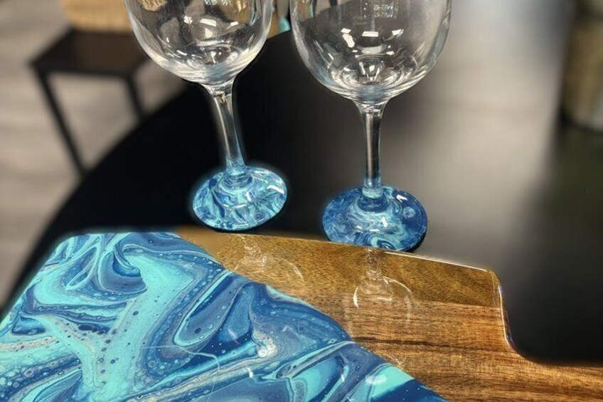 Two clear glass wine glasses on a wooden tray with a blue marble pattern. 3