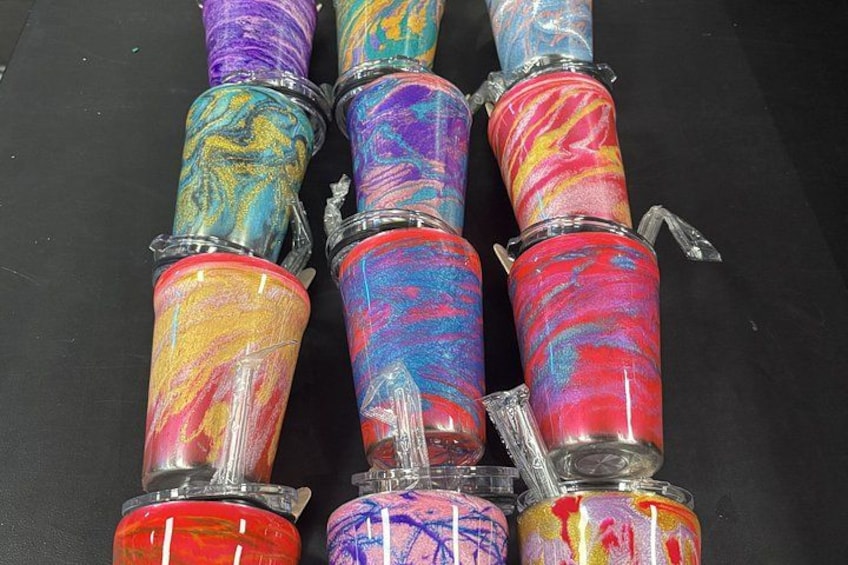 A collection of colorful, cylindrical containers with a marbled pattern, sealed with plastic wrap and metal bands. 2