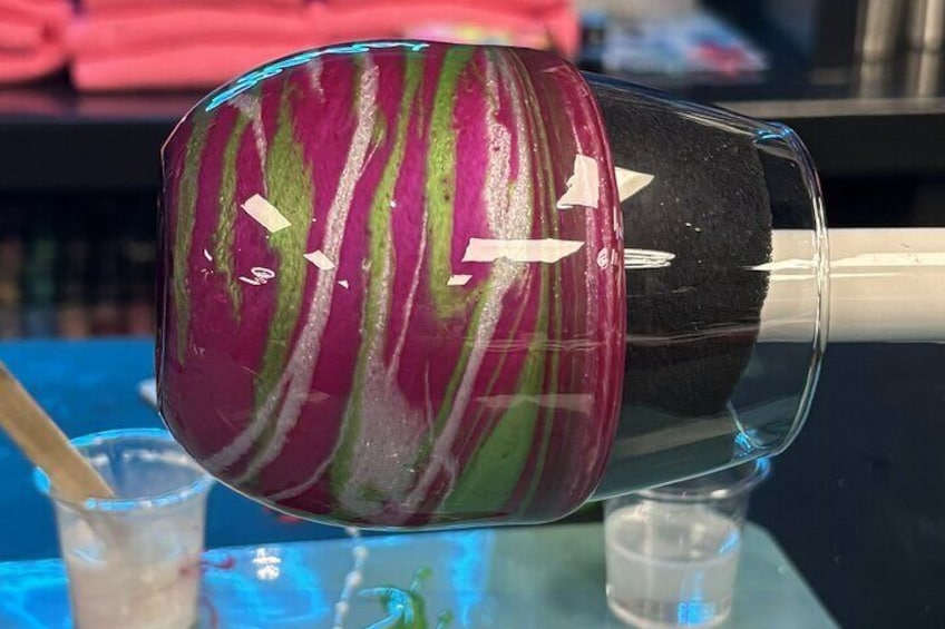 A glass with a marbled pattern and a straw inside. 4