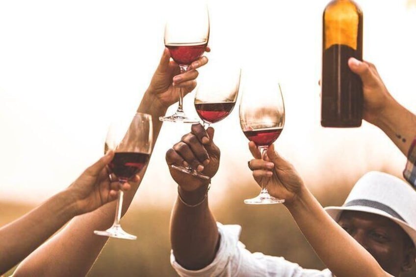 People toasting with wine glasses, holding a bottle, and a smartphone. 3