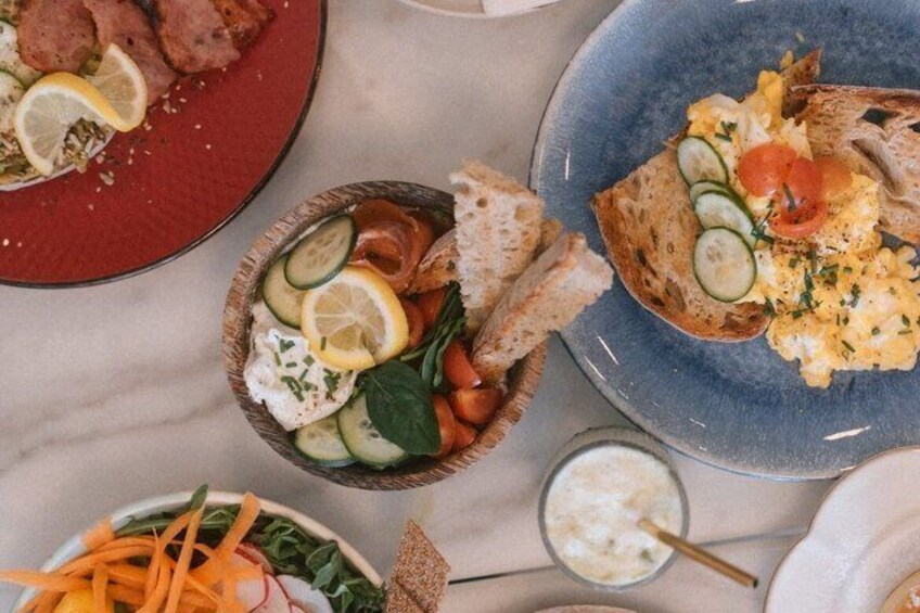 A variety of food items on plates, including scrambled eggs, bread, and a salad with vegetables. 1