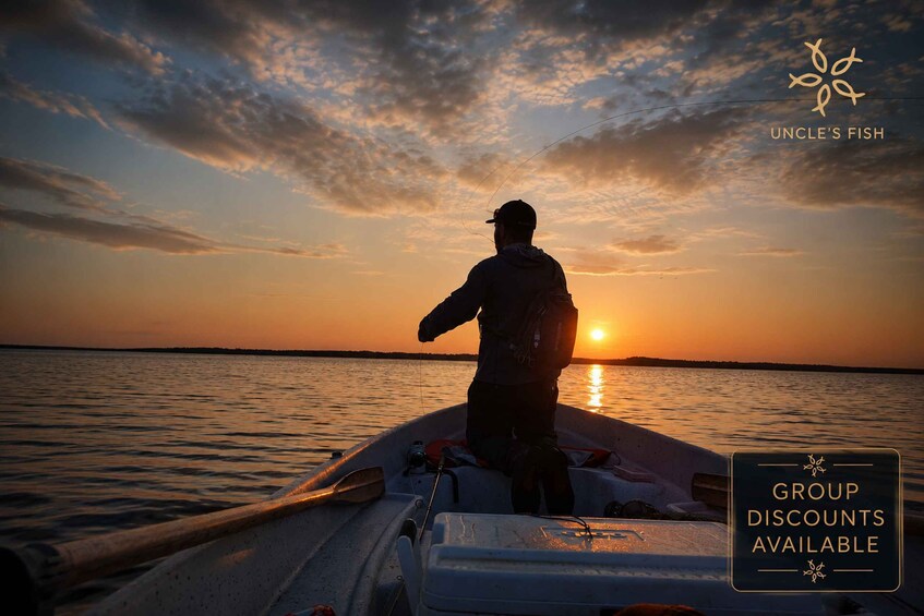 A person fishing on a boat during sunset. 1