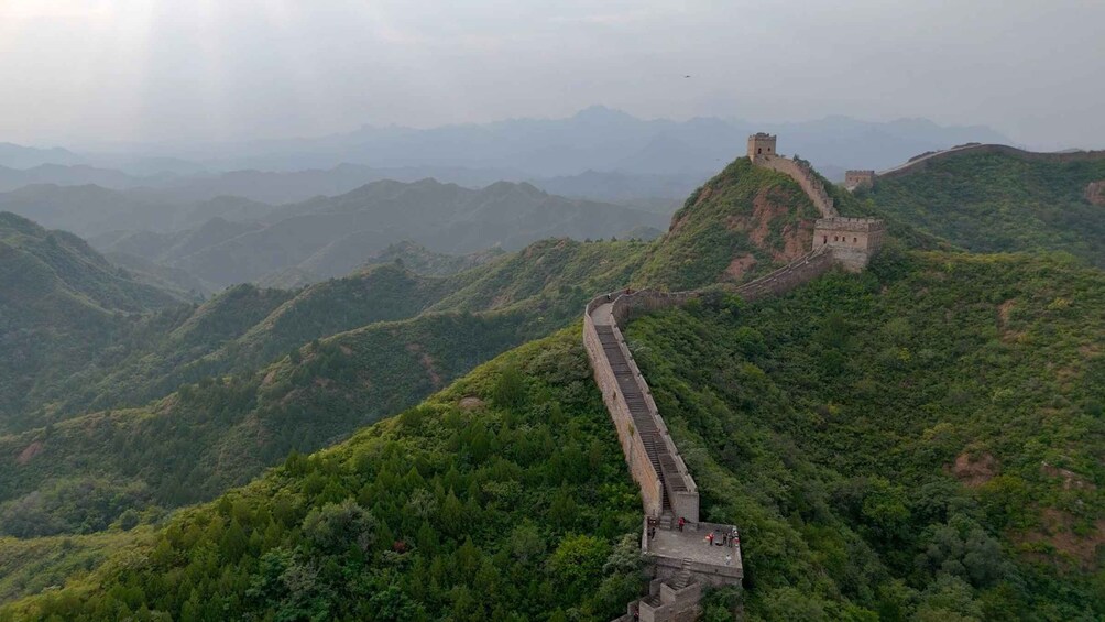 The Great Wall of China winding through lush green hills. 4