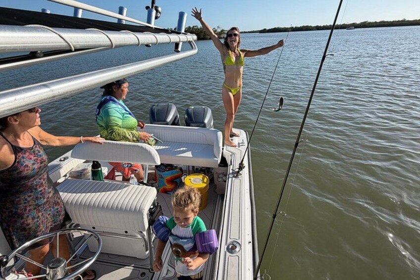 A boat with people on it, a child holding a toy, and a bridge in the background. 1