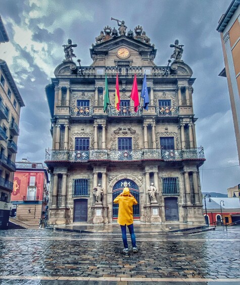 A historic building with ornate architecture, a clock, and flags. 2