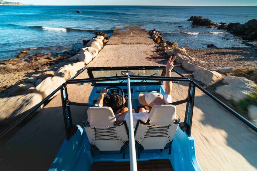 A boat moving along a rocky shore with waves crashing onto the beach. 1