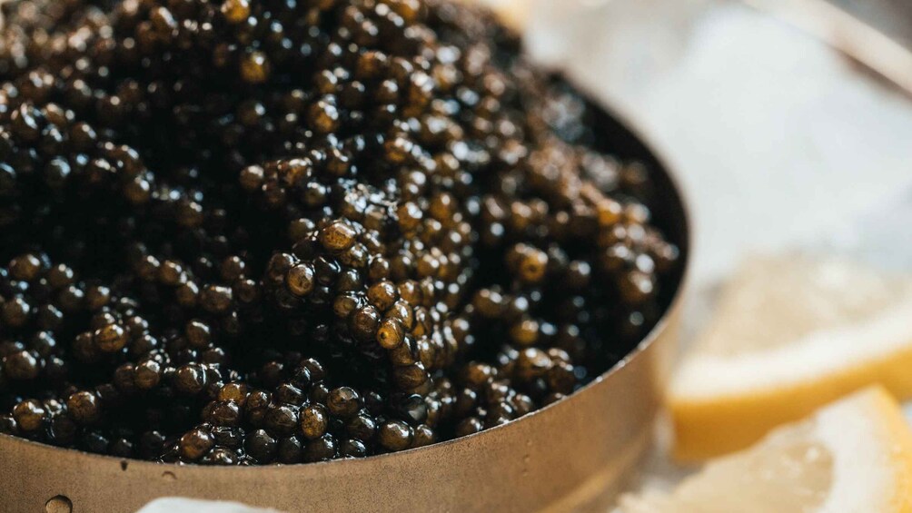 Un bol de caviar noir accompagné de tranches de citron. 4