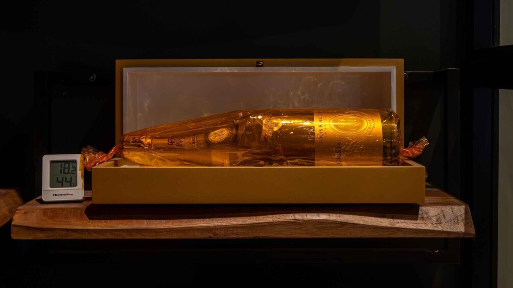 Une vitrine contenant une grande bouteille, un thermomètre et une surface en bois. 5