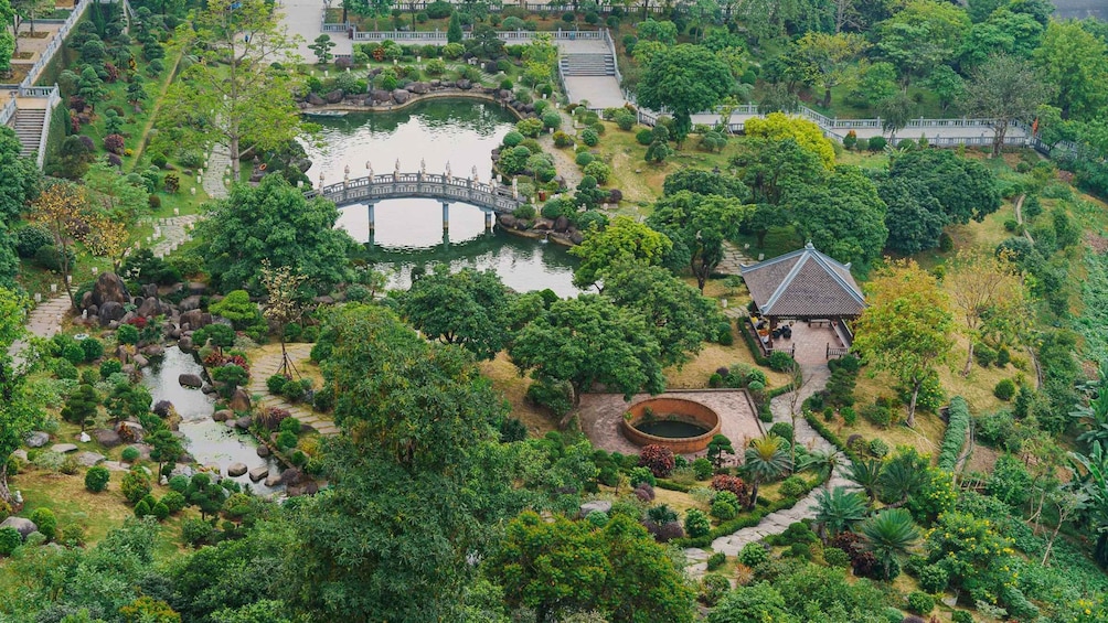 A lush garden with a pond, a bridge, and a pavilion. 5
