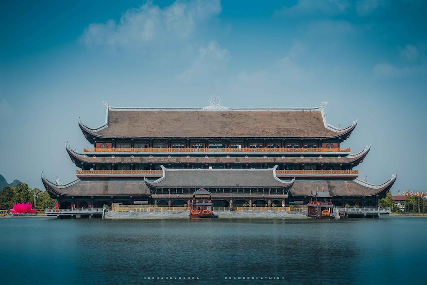 A traditional multi-tiered building with a water body in front. 1