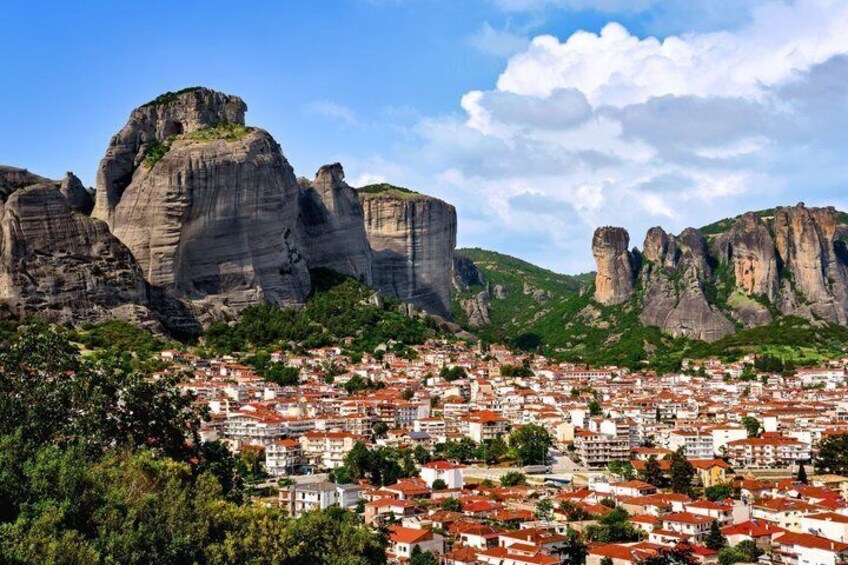 A town nestled between rocky cliffs with red-roofed buildings. 2