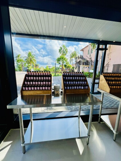 A storefront with two wooden display cases of products, a metal table, and a view of a street with palm trees and buildings. 4