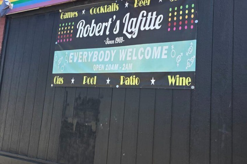A sign for Robert's Laffitte, a bar open from 10 AM to 2 AM, offering cigars, pool, patio, and wine. 1