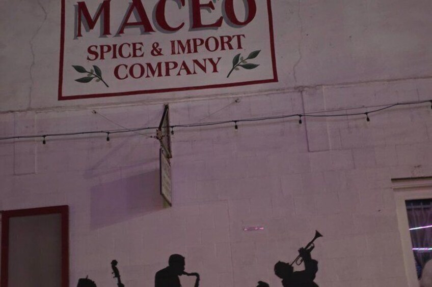 A sign for Maceo Spice & Import Company on a building wall. 3
