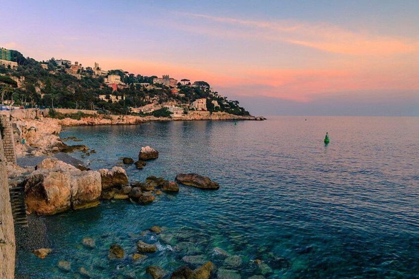 A coastal landscape with clear water, rocks, and a distant green buoy. 3