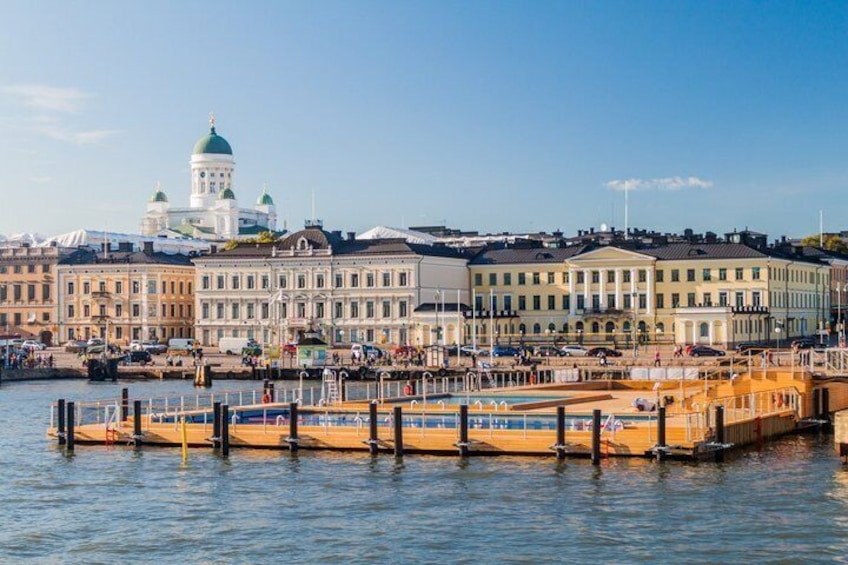 A waterfront with buildings, a dock, and a clear sky. 1