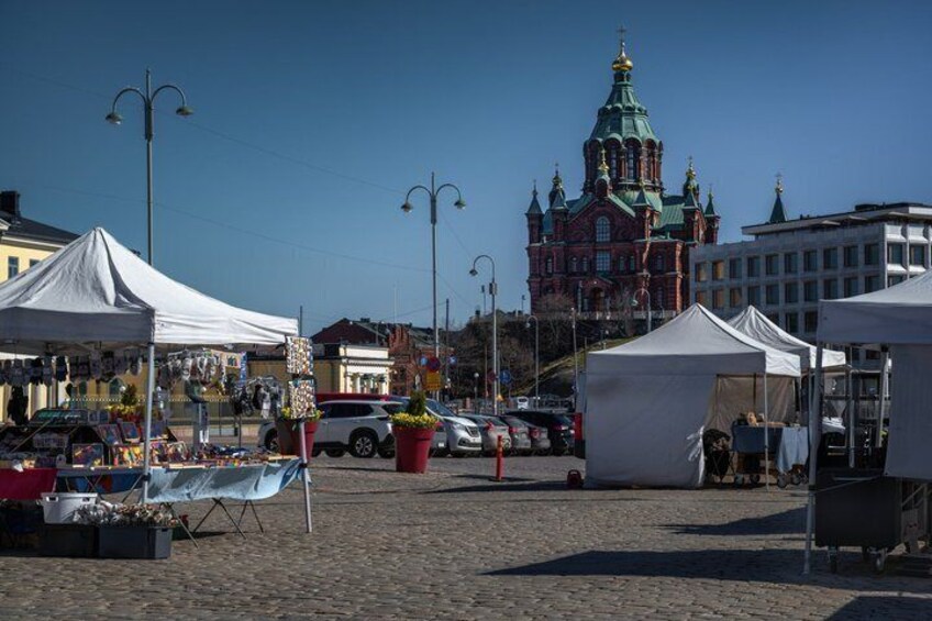A market with tents, a church, and cobblestone streets. 3