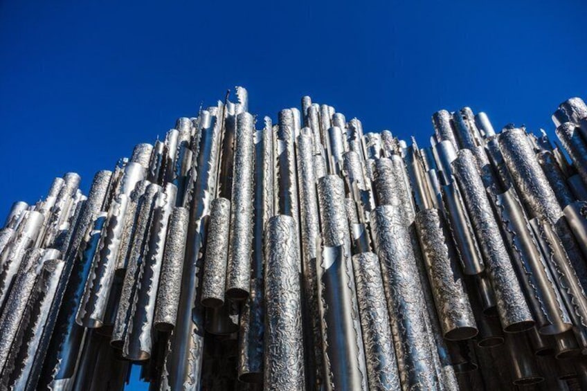 A collection of cylindrical metal objects stacked against a clear blue sky. 4