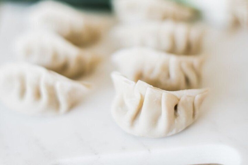 A close-up of dumplings on a white surface. 3
