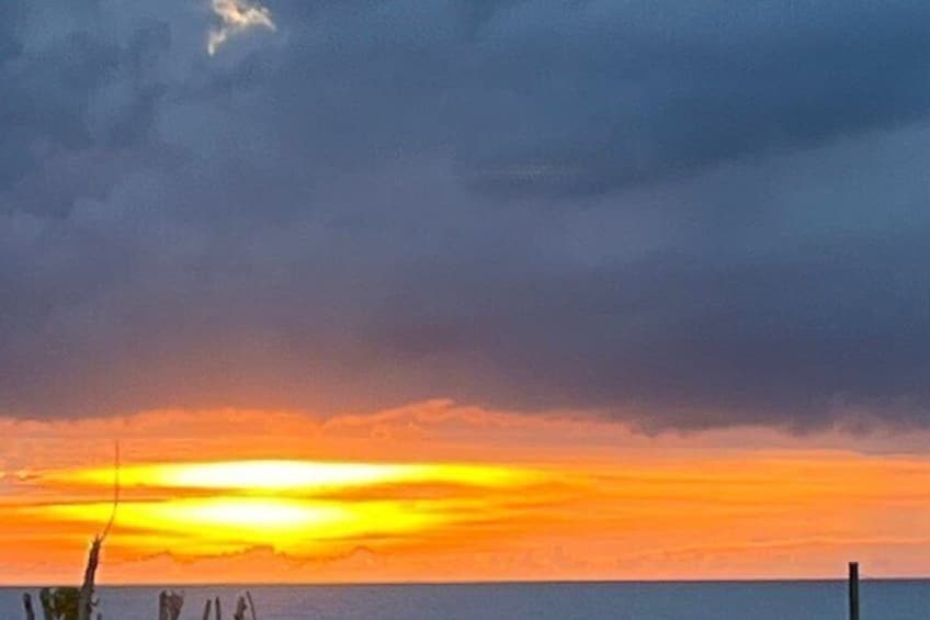 A sunset over a body of water with a cloudy sky. 4