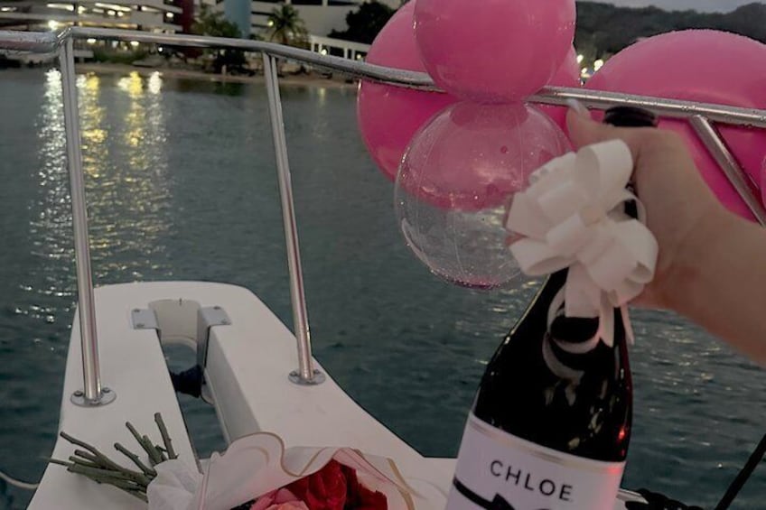 A boat with pink decorations and a bottle labeled 'CHLOE' on the deck. 1