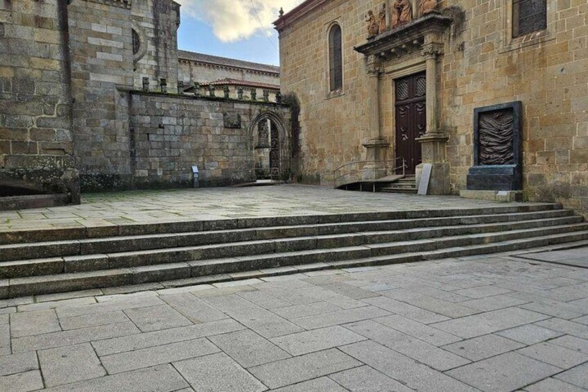 A stone building with a large wooden door and steps leading up to it. 5