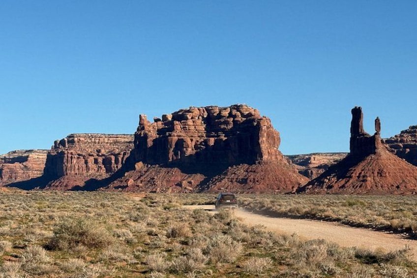 A desert landscape with red rock formations and a dirt path. 2