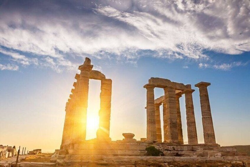 Ancient stone ruins with columns, set against a sunset sky. 1