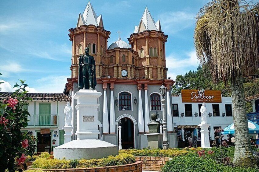 A historic building with a clock tower, a statue in front, and a sign for 'Don Oscar.' 4