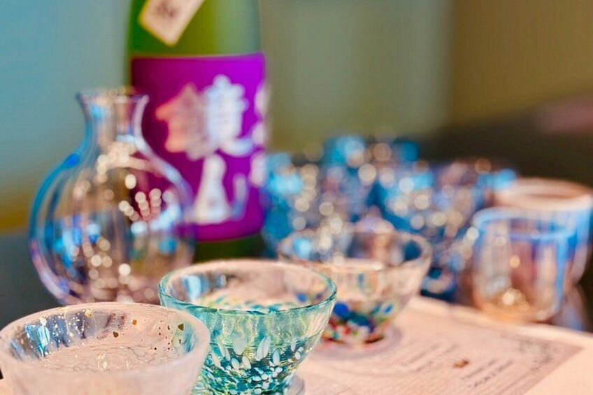 A collection of glassware, including bowls and a bottle, with a label featuring Japanese characters. 1