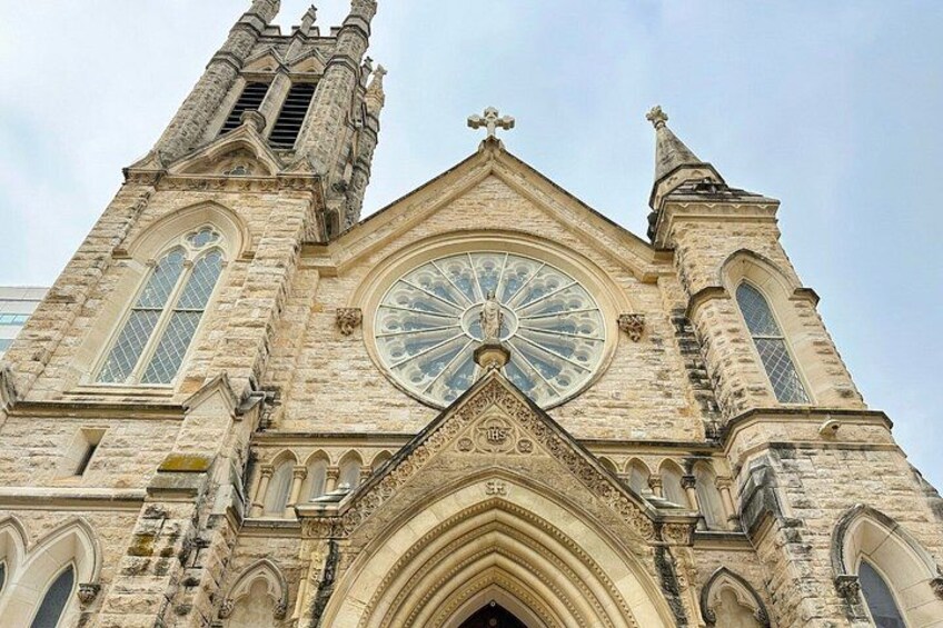 A Gothic-style church with a large circular stained glass window, two tall spires, and a pointed arch entrance. 2