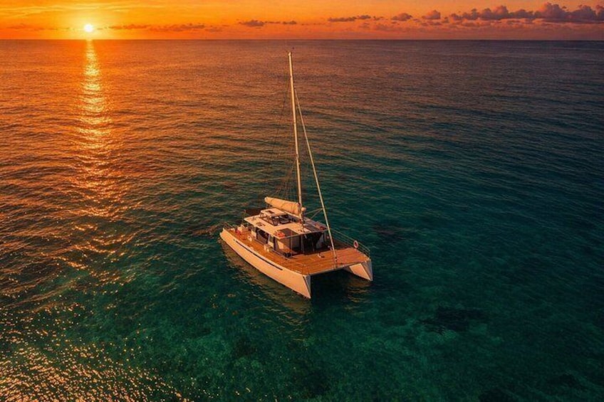 A sailboat on calm ocean waters at sunset. 1
