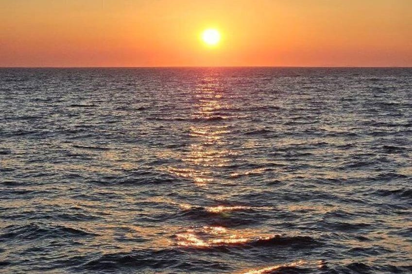 A sunset over the ocean with sunlight reflecting on the water. 3