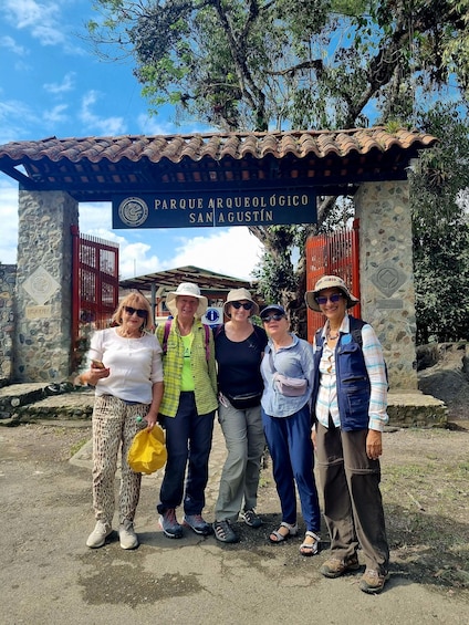 A group of people standing in front of the Parque Arqueológico San Agustín entrance. 4