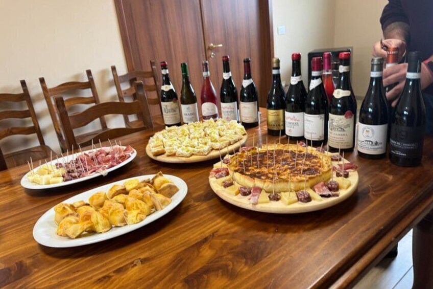 A wooden table with various dishes and wine bottles. 4