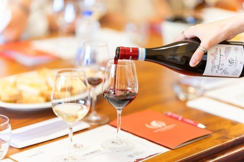 A person pouring wine into a glass. 3